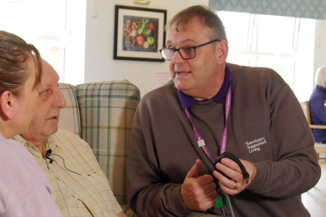 A resident learning about technology enabled living packages from a member of staff