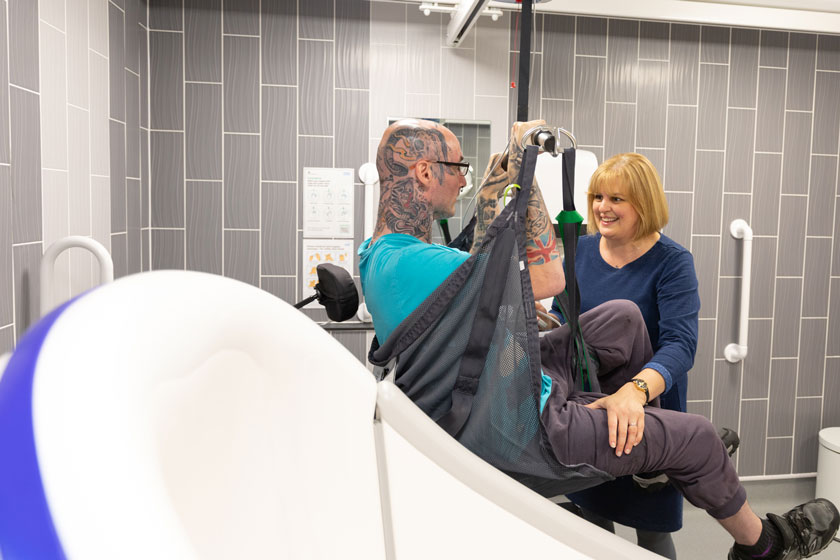 Award winning service manager using a hoist to lift a resident at Trowbridge