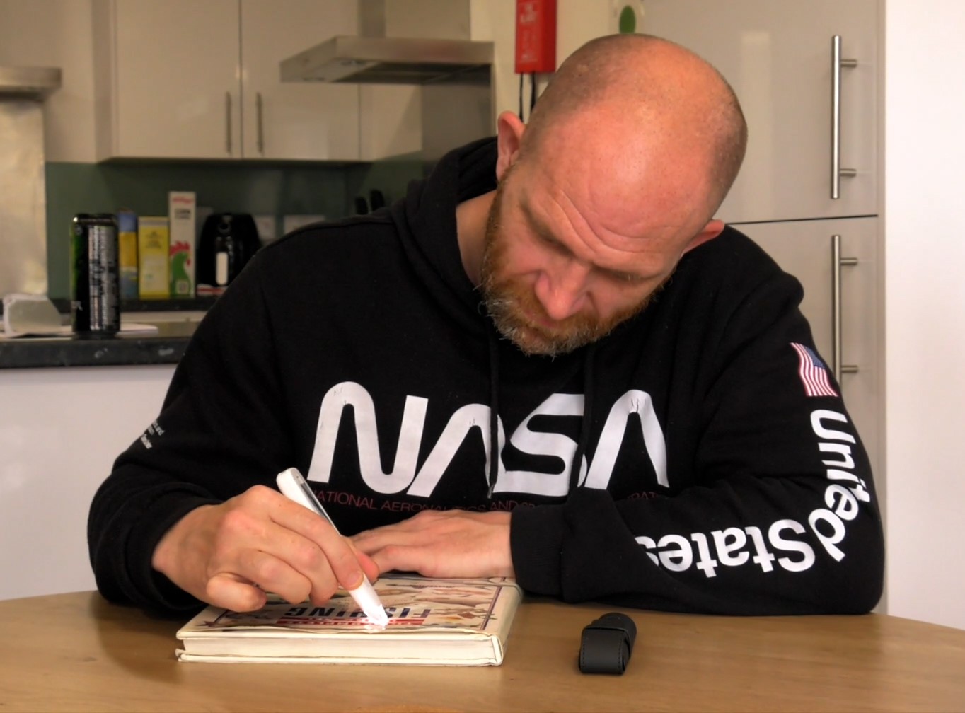 Man reading his fishing magazine with support from a reading pen