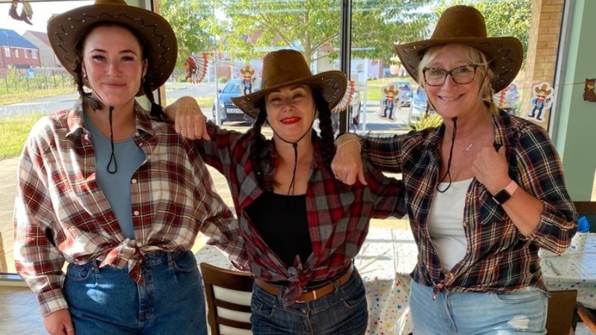 Three members of SSL staff dressed in plaid shirts and cowboy hats