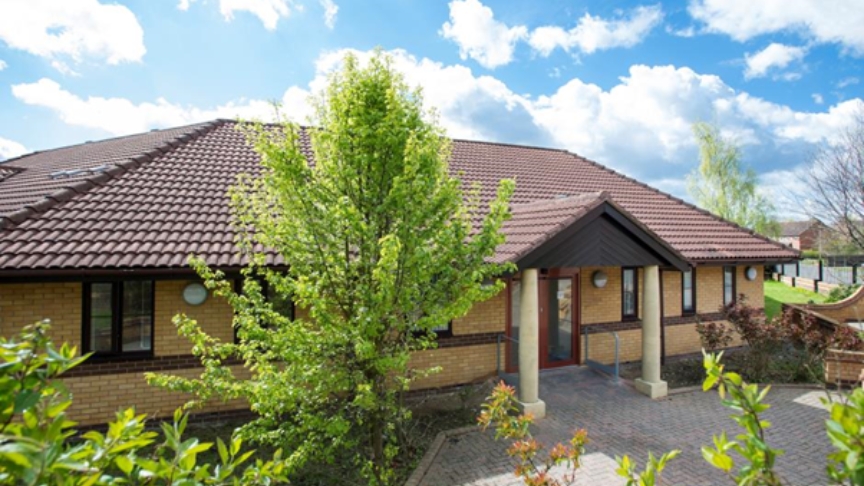 Exterior of Skelton Court, a single story building on a sunny day with blue sky and white fluffy clouds
