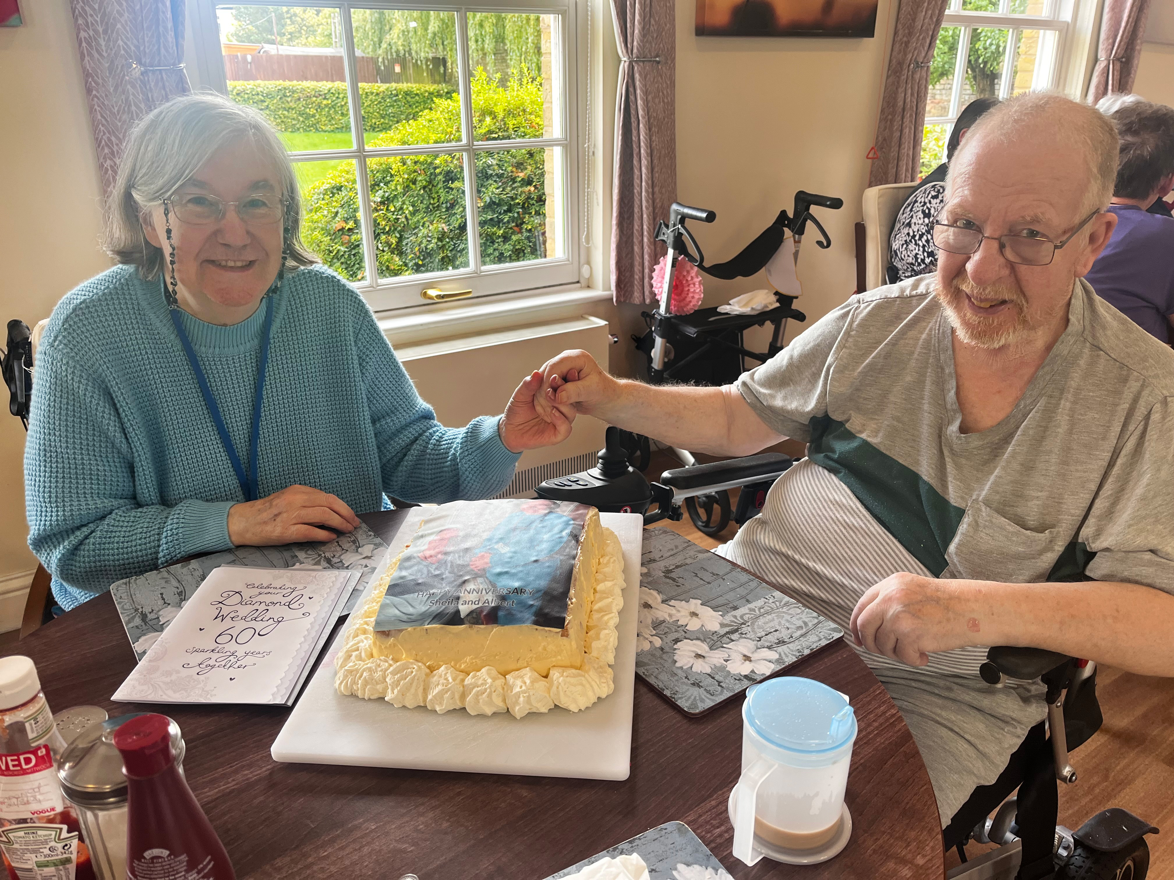 A couple who have been married for 60 years sat together in their retirement home and smiling