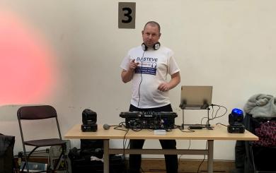 Steve behind his DJ decks, with headphones around his neck