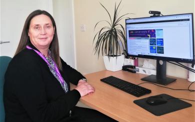 Local service manager Caroline Addison sitting at her desk facing away from her computer screen towards the camera