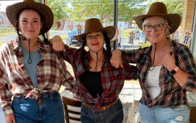 Three members of SSL staff dressed in plaid shirts and cowboy hats