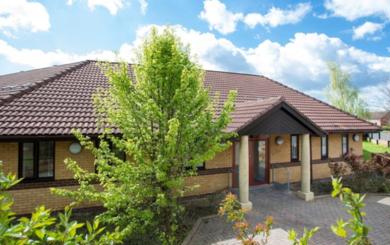 Exterior of Skelton Court, a single story building on a sunny day with blue sky and white fluffy clouds