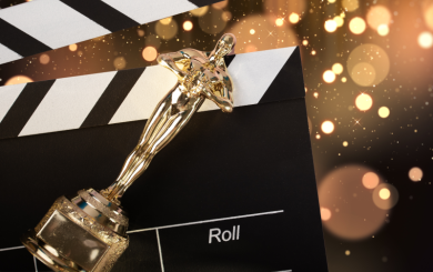 A gold Oscar award lay across a cinematic clapperboard.