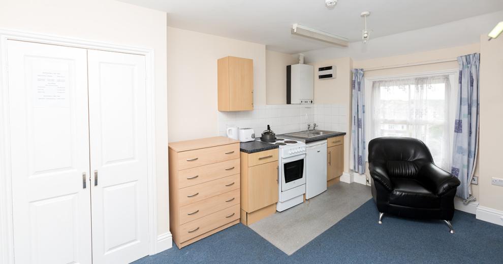Compact, functional kitchenette, including oven, hob and fridge. In a spacious studio flat.