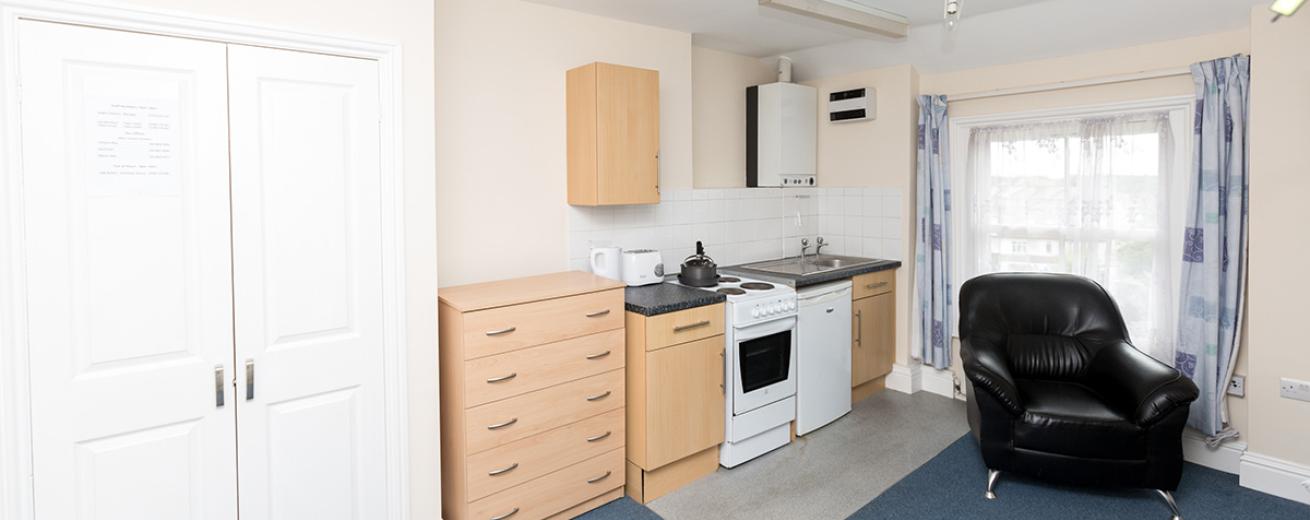 Compact, functional kitchenette, including oven, hob and fridge. In a spacious studio flat.