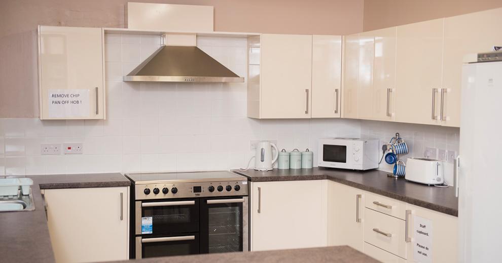 Cream coloured kitchen units with classic stainless tell appliances.