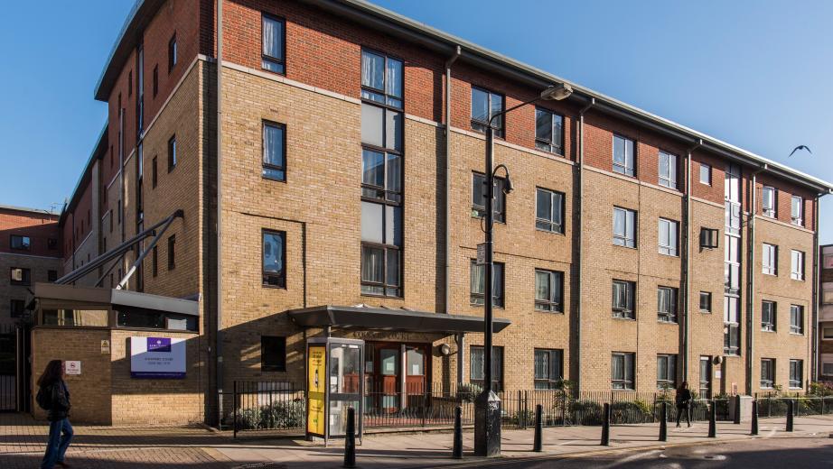 A four storey new-build brick apartment block, located by a main road with gated access to the entrance and a secure gated carpark.