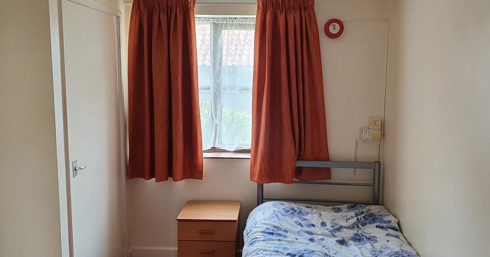 Minimal, single bed, room featuring plenty of storage opportunities and a good-sized widow providing fresh air.