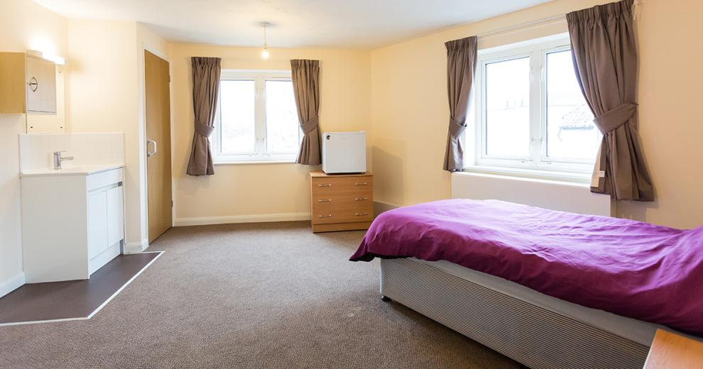 Considerable sized comfortable singled bedded room with plenty of room for all accessibility needs with small wash area and mirror separate to the communal washing facilities.
