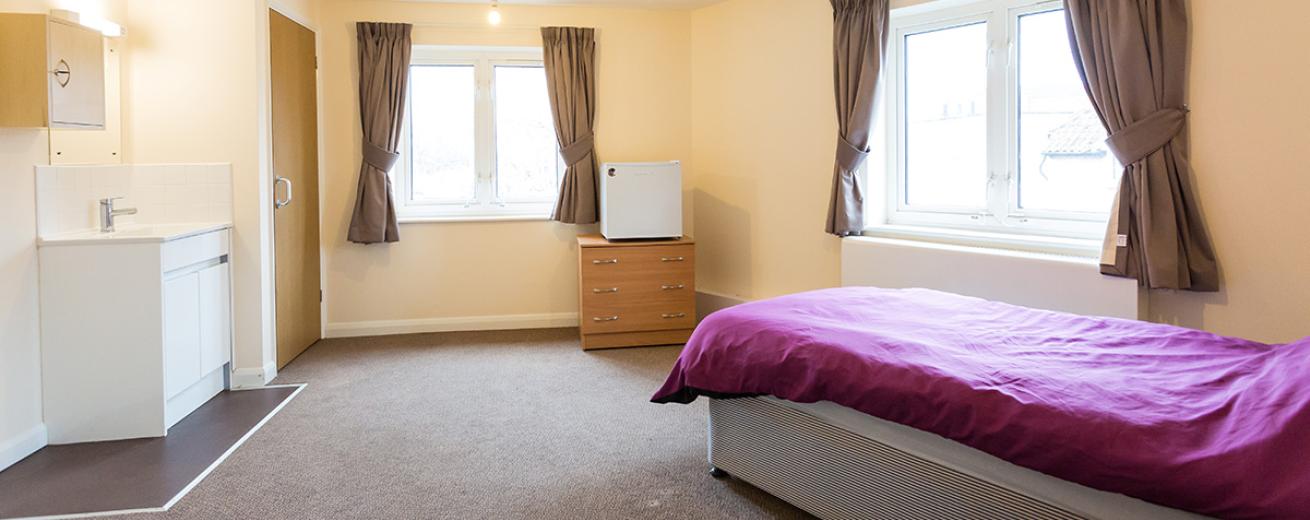 Considerable sized comfortable singled bedded room with plenty of room for all accessibility needs with small wash area and mirror separate to the communal washing facilities.