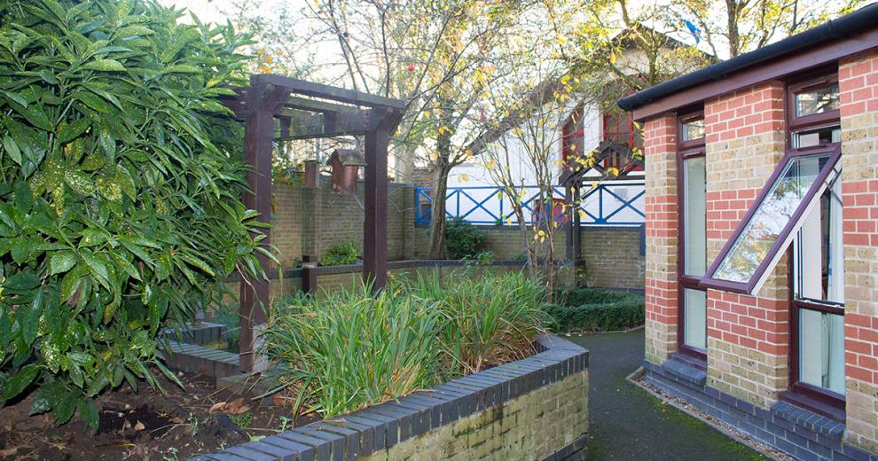 Secluded seating area, given privacy by the thriving plants in the raised bedding wall.