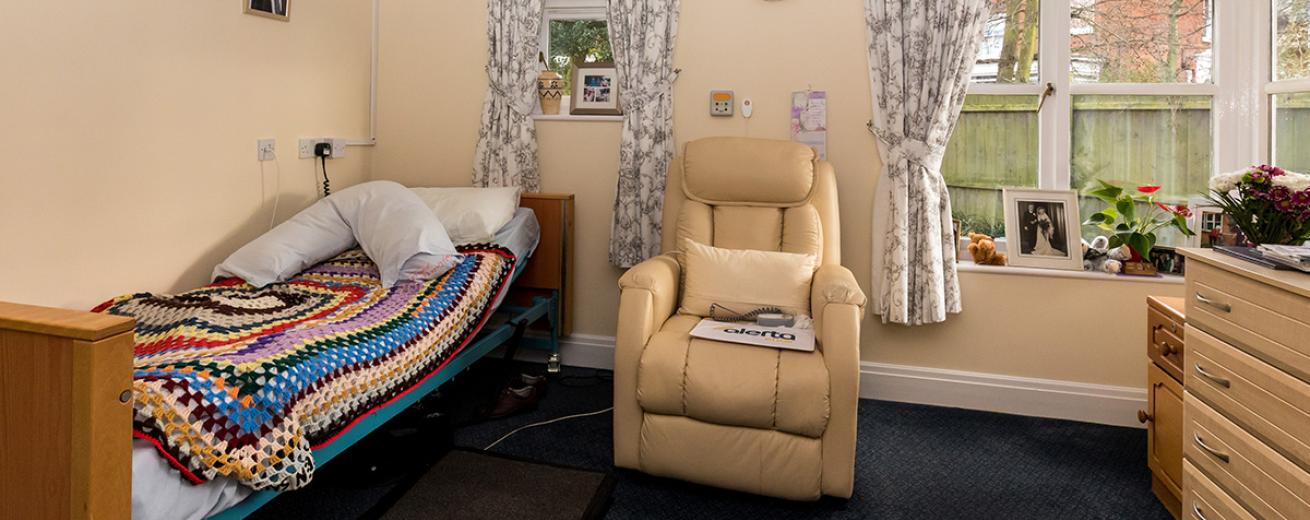 Comfortable, well-equipped bedroom, with assisted living features for the single bed and electric cream plush armchair. With multiple windows allowing an airy feel, and an abundance of homely touches.