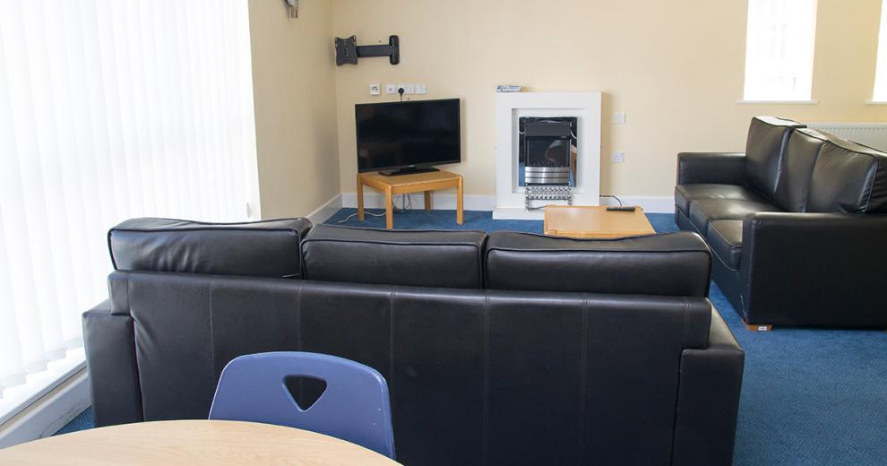 Room dividing seating area radiating from a classic electric fireplace and surround.