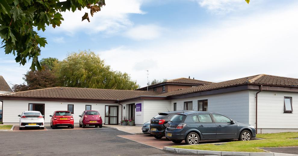White wood panelled, single storey exterior at the residential care home Shaftesbury Court.