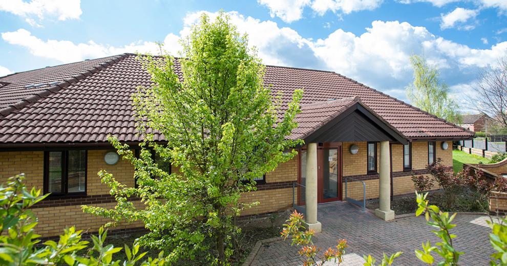 Detached, bungalow with grand inviting entry to the home. Surrounded by enough placed small trees and large plants.