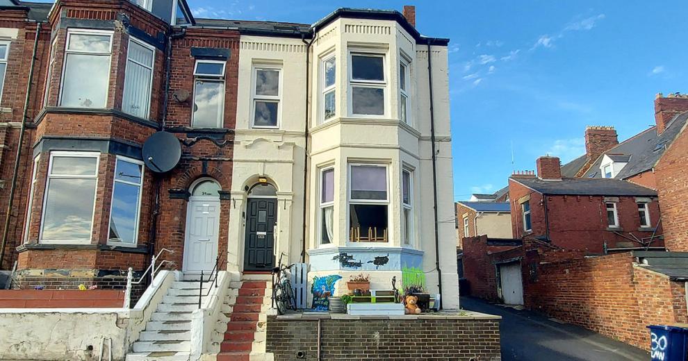 Grand, end of terrace property with stepped access and large bay windows, rendered in a cream colour to stand out against the adjoining properties.