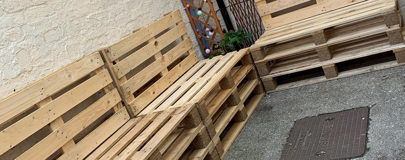 Contemporary pallet styled garden furniture placed in a petite communal garden area.