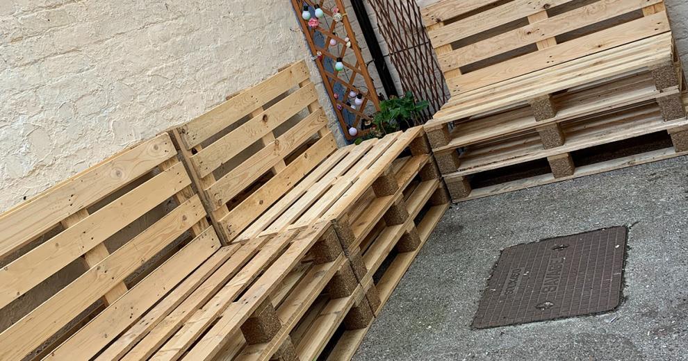 Contemporary pallet styled garden furniture placed in a petite communal garden area.