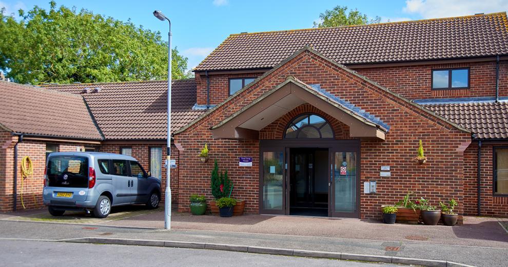 Attractive, red, and brown brick detached property, with triangular design on the front which guides towards the double door entrance. The rest of the property wraps around the central entranceway.