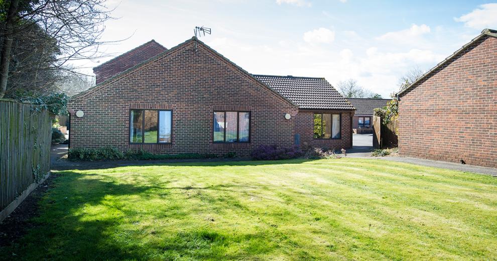 Simplistic, large grass garden with access either side of the property.