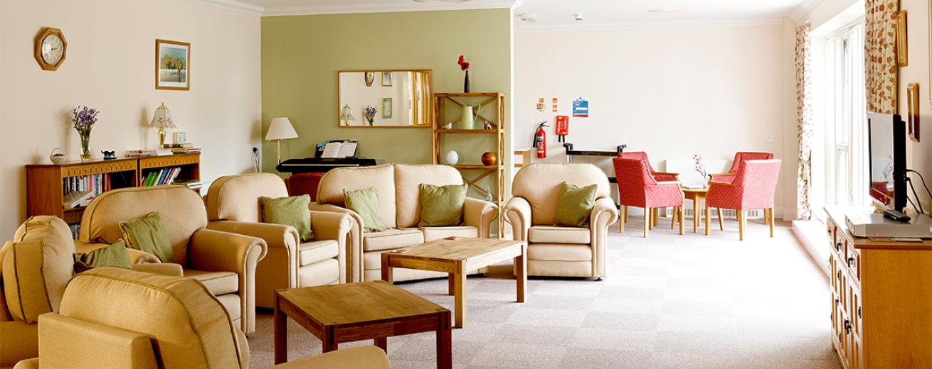 A cosy seating area filled with soft cream leather sofas and armchairs perfectly circled around the television unit.