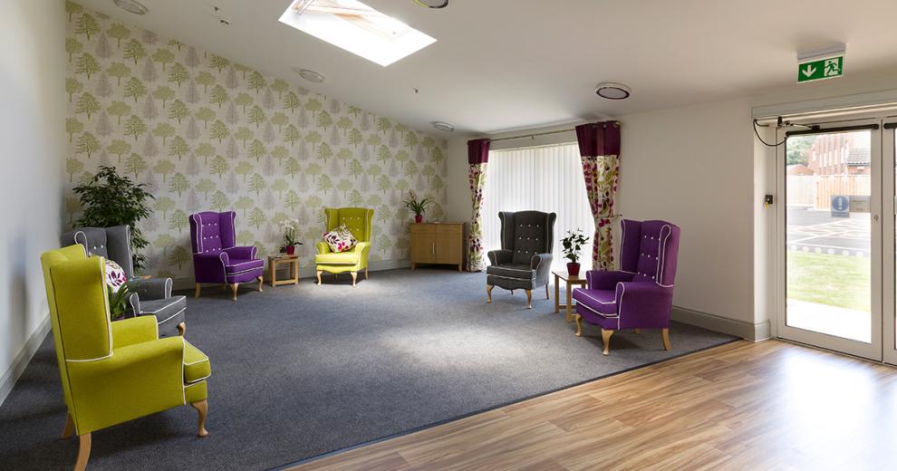 Cosy, semi-circle seating area, featuring grand ornate armchairs in co-ordinating, deep purple, lime green and grey colourways.