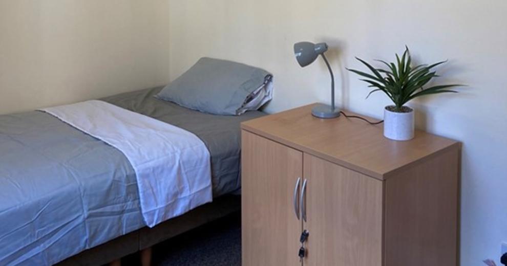 Muted toned bedroom décor, with lockable storage and simple accessories.