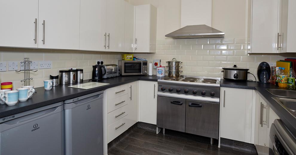 Industrial style kitchen with double stainless-steel oven and hob. Double fridges, modern cooking appliances and mass amounts of units.
