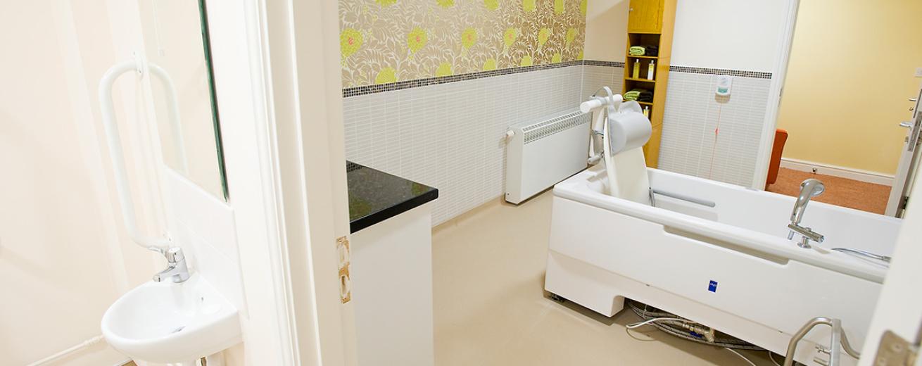 The floral feature wall adds warmth and decoration to the white and beige colour scheme. The bathroom features an assisted bathing bath tub with plenty of space to manoeuvre comfortably with ease, the toilet area is joined but with a separating door for privacy.