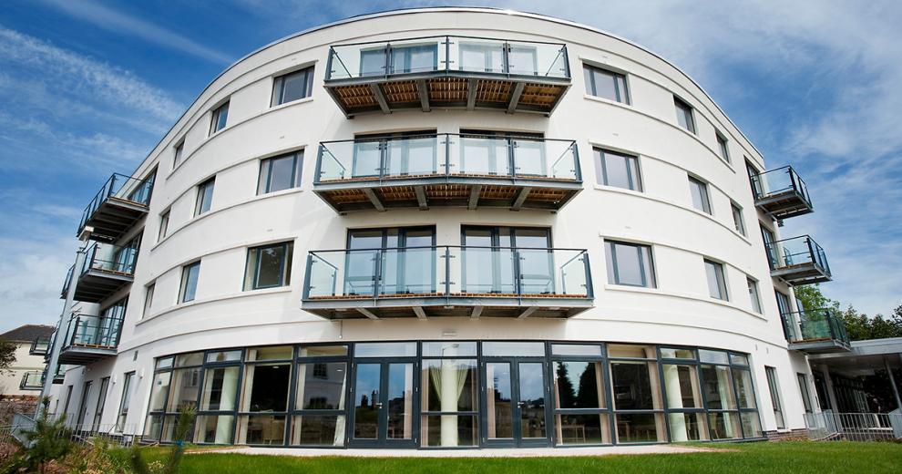 Uniquely curved retirement living property. The building features an array of oversized windows and french doors as well as personal balconies for a bit of personal outdoor space.