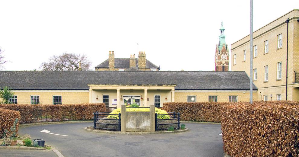 The entrance to the retirement community is accessed by a one way circular roundabout. The period designed stone built building is the main feature with the covered stone built porch with chunky columns supporting the roof. The rest of the building is built with soft coloured yellow bricks and long rectangular windows.