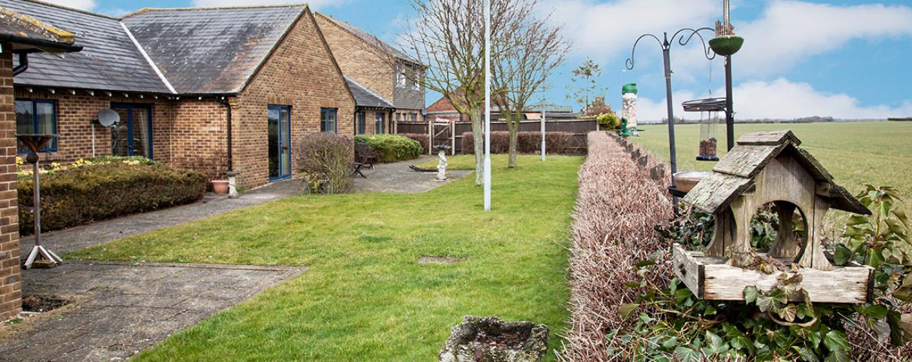 A petite garden area that spans the length of the property, is made up of a paved access all around the perimeter of the building then onto the grassed area. A waist height hedge marks the boundary of the property but allows views onto the neighbouring field.