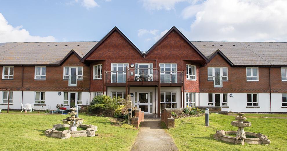 The beautiful two-storey property is designed with the ground floor covered in white render and the first floor in traditional red brick. The entrance is accessed by a pathway leading you through the grassed areas and stone water features either side of the walkway.