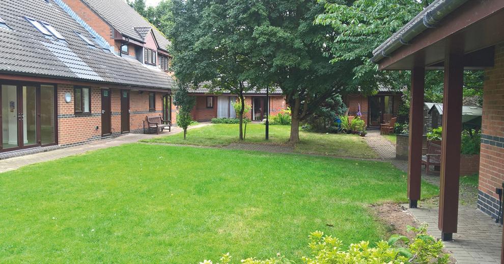 Spacious grass garden in the centre courtyard of the property, growing mature trees.