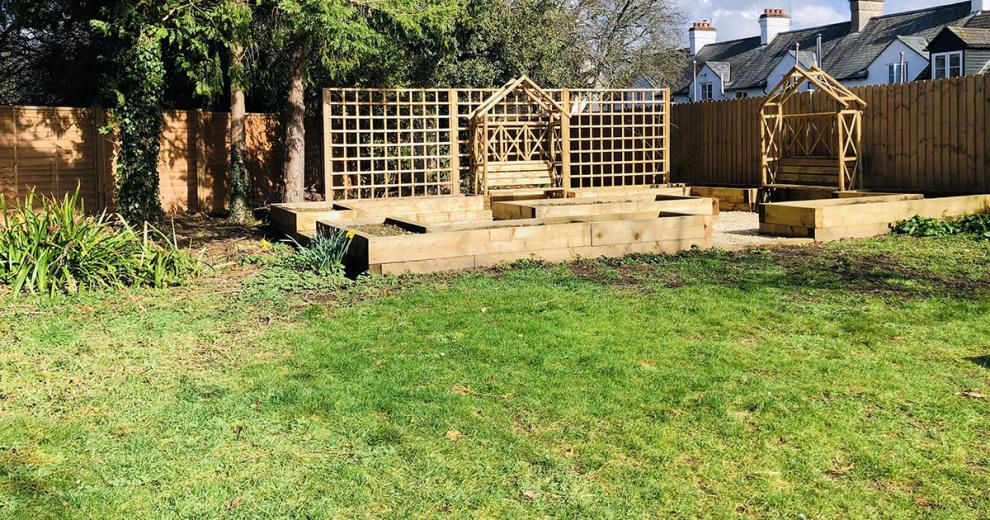 Good sized grassed garden, with luscious trees and shrubbery. A raised decking area is home to a light wooden stained shed.