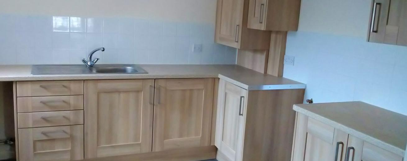 Gorgeous wood panelled kitchen cabinets a slightly lighter wooden flooring, finished with a soft marble effect worktop.