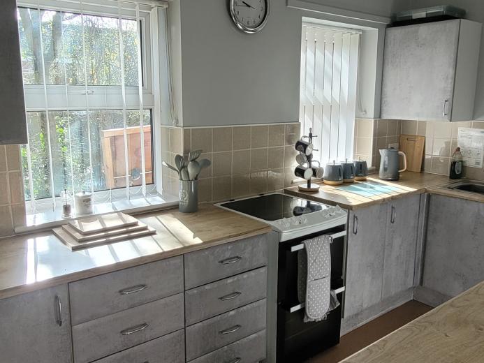 Neutral toned kitchen with grey cabinets and a wooden finish