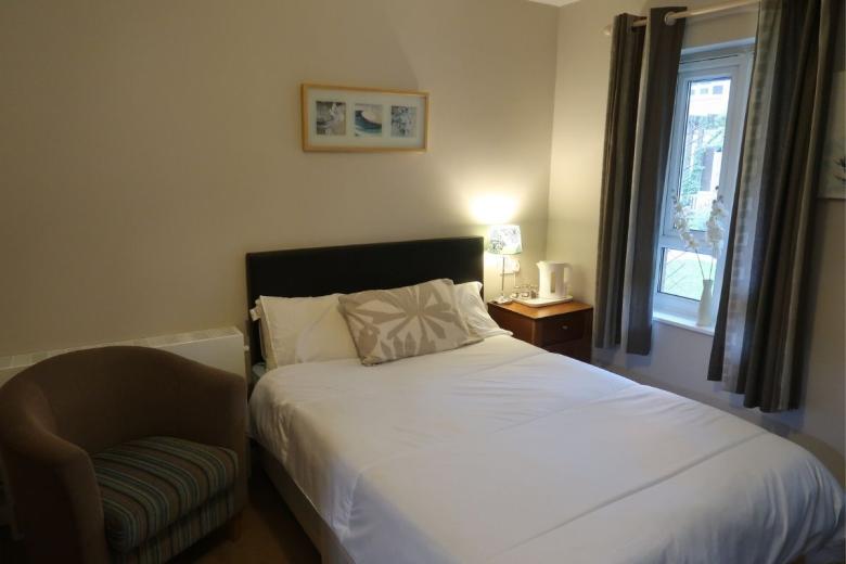 Double bedroom with armchair, bedside table and window