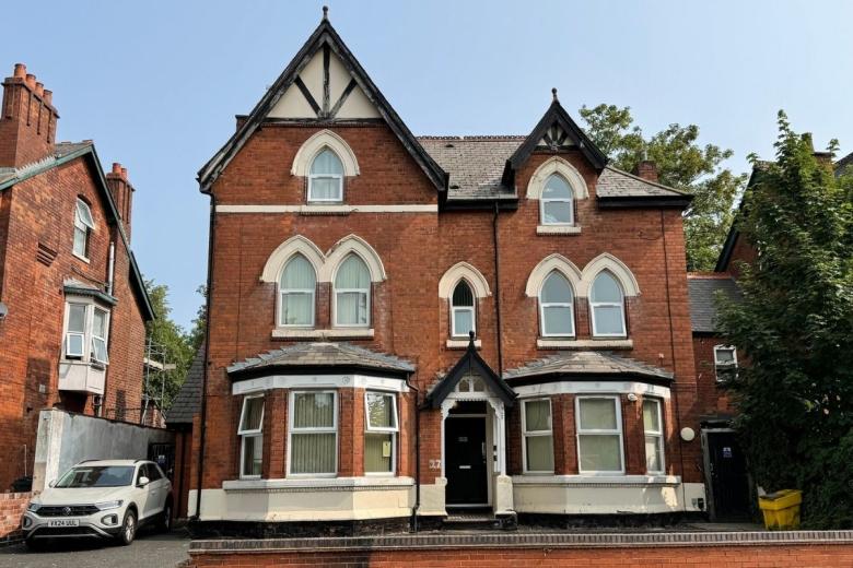 Exterior view of Sandwood House, a red brick supported accommodation property with period architectural features.