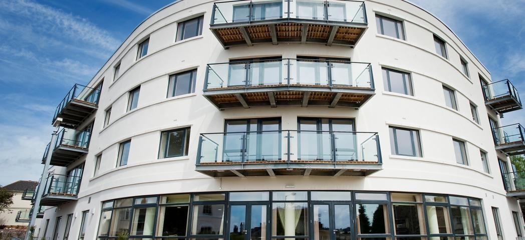 Uniquely curved retirement living property. The building features an array of oversized windows and french doors as well as personal balconies for a bit of personal outdoor space.