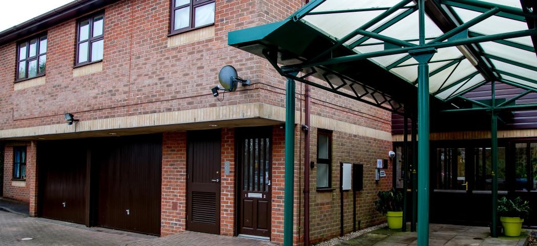 Large brick facility with dropped curbed access points and stepless entry. Providing onsite parking and twelve one-bedroom flats at Hilltop House. 