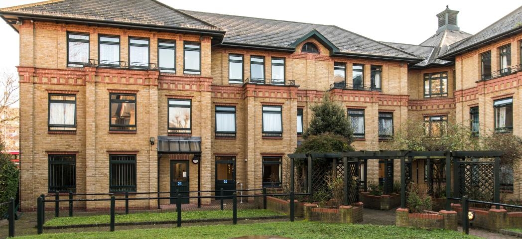 The characteristic, yellow brick built corner plot building, with a decorative red brick addition above the storey elevation wrapping the property and a magnitude of dark framed windows decorating the exterior. The centre of the property holds a well-maintained grassed area with brick paved walkway, as well as wooden pergola covering the entranceways into the property.