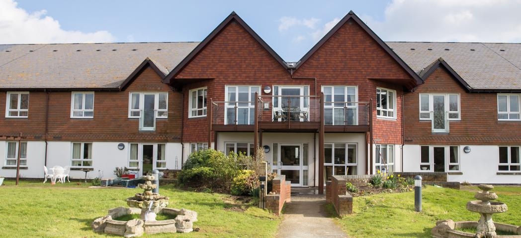 The beautiful two-storey property is designed with the ground floor covered in white render and the first floor in traditional red brick. The entrance is accessed by a pathway leading you through the grassed areas and stone water features either side of the walkway.