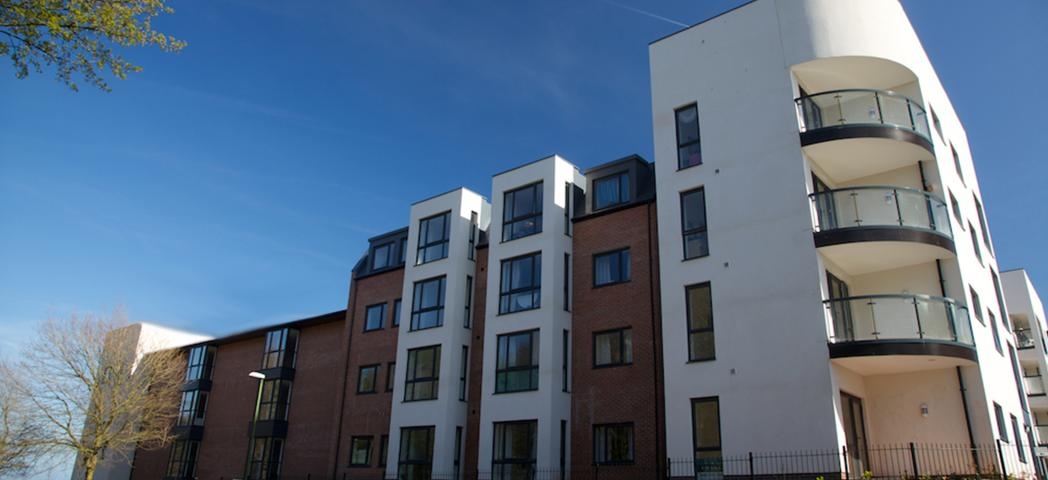 Modern four storey retirement living complex built on a corner plot of land. The corner has been curved to create beautiful balconies for the properties. Traditional red brick as well as white render have been used on the protruding elements of the property.