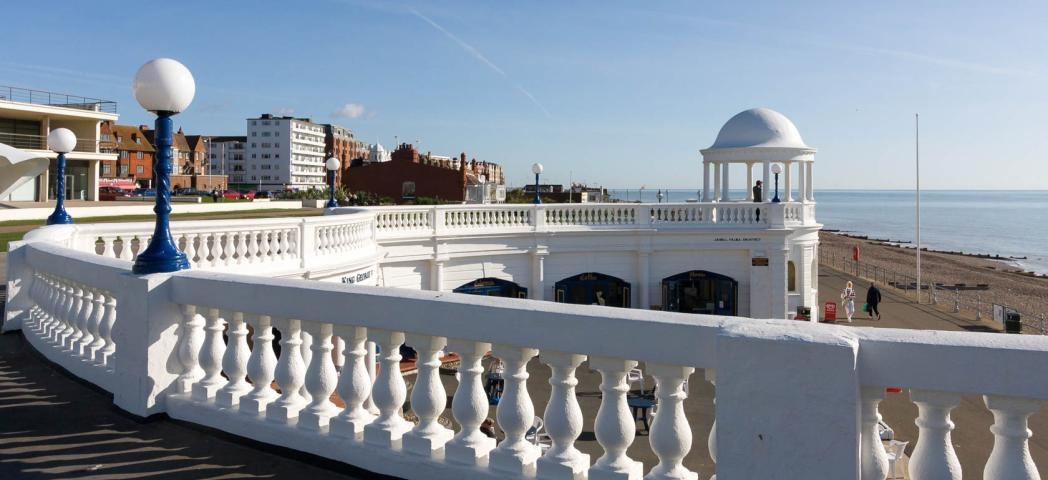 Stand out brilliant white pavilion, contrasting with the dark coloured beachfront and pale blue sea. 