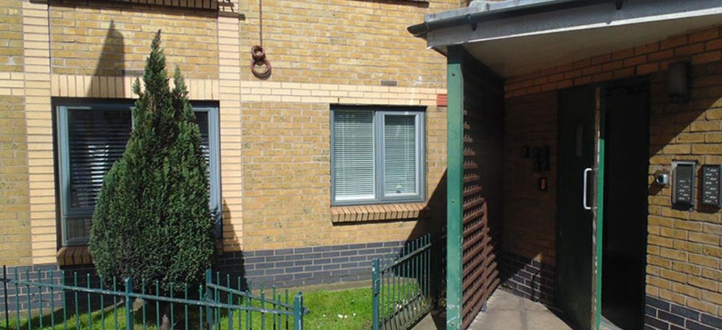 Yellow brick built supported living property with canape sheltering above the entranceway. 